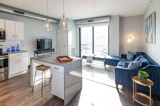 a living room with a kitchen and a blue couch at Soll, Iowa   