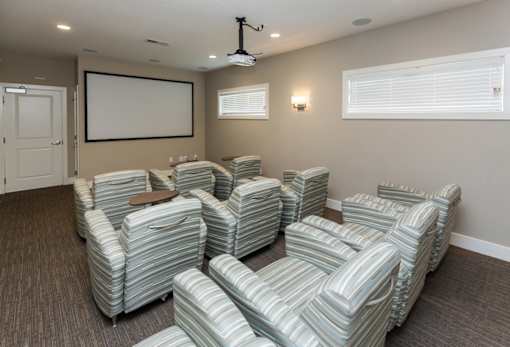 A room with grey striped chairs and a whiteboard on the wall.