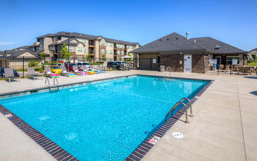 our resort style swimming pool is next to our building with our apartments in the background at Stonegate Crossing Apartments, Clive, IOWA