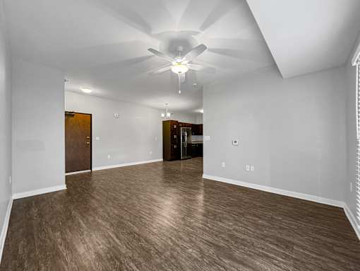 an empty living room with a ceiling fan at Stonegate Crossing Apartments, Clive, IA
