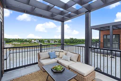 Rooftop terrace with pergola and outdoor sectional sofa at The Flats at West Glen Apartments, Iowa