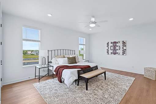 Spacious bedroom with platform bed and patterned area rug at The Flats at West Glen Apartments, Iowa, 50266