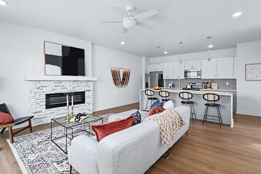 Open concept living area with fireplace and kitchen island at The Flats at West Glen Apartments, West Des Moines, 50266