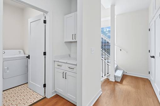 Upper floor hallway with laundry and cabinetry at The Flats at West Glen Apartments, Iowa, 50266