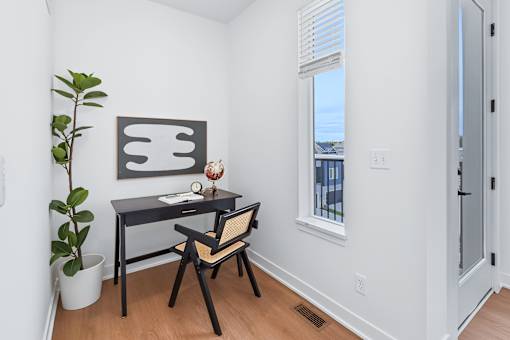 Home office nook with black desk and woven chair at The Flats at West Glen Apartments, West Des Moines, Iowa