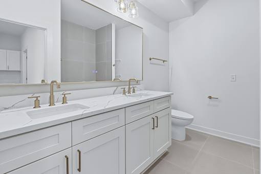 Bathroom with dual vanity and champagne bronze faucets at The Flats at West Glen Apartments, West Des Moines, IA 50266