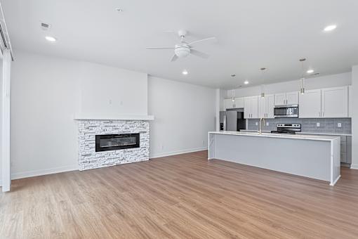 Open floor plan with stone fireplace and modern kitchen at The Flats at West Glen Apartments, West Des Moines, 50266