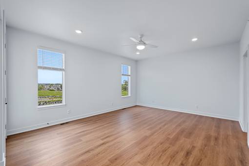 Empty bedroom with wood flooring and ceiling fan at The Flats at West Glen Apartments, Iowa