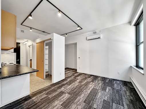 A room with a black counter top and brown and black tiled flooring at The Des Moines Building Apartments, Des Moines, IA