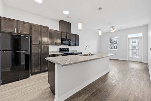 A kitchen with a white counter and black appliances.