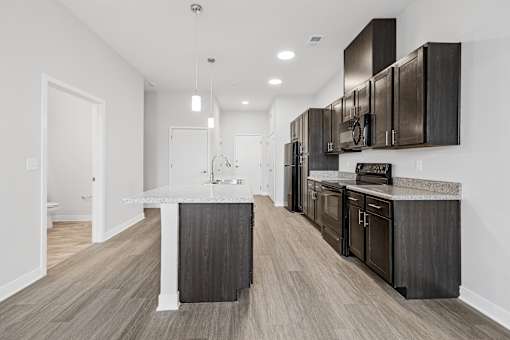 A modern kitchen with dark wood cabinets and a white countertop.
