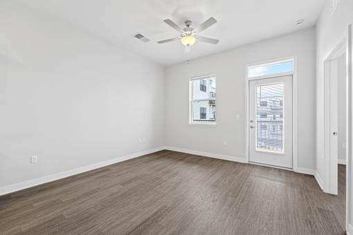 A room with a ceiling fan and a window with blinds.