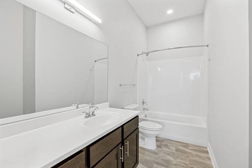 A white bathroom with a sink, toilet, and bathtub.