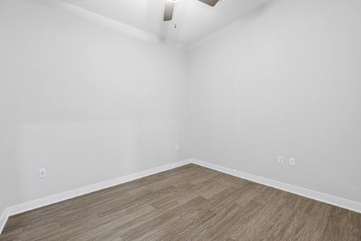 A room with a light brown floor and white walls.