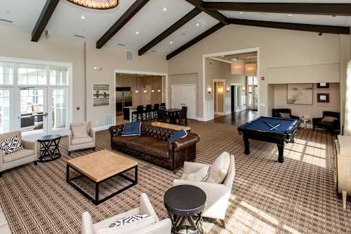 a large living room with a pool table and couches at The Winhall of Williams Pointe Apartments, Waukee, IA, 50263
