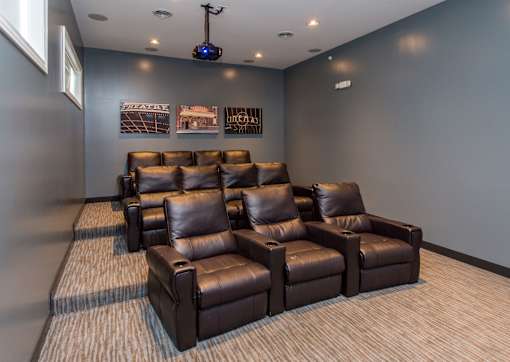 a large media room with leather couches and chairs at The Winhall of Williams Pointe Apartments, IOWA, 50263