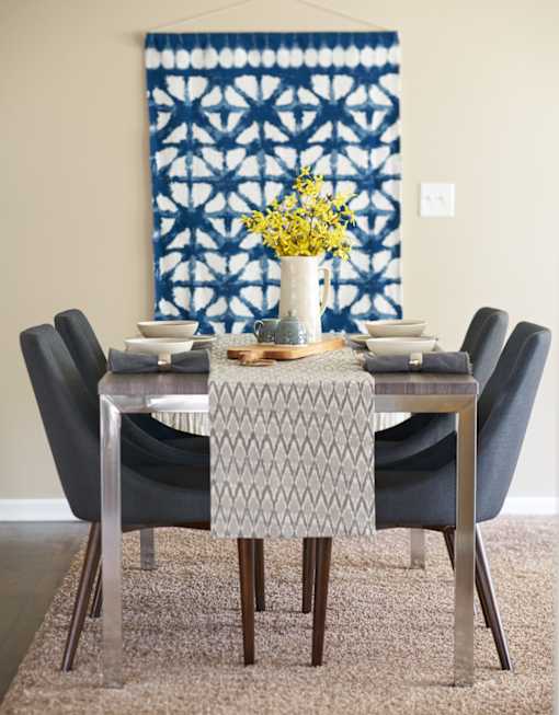 a dining room with a table and chairs and a blue and white tapestry at The Winhall of Williams Pointe Apartments, Waukee, IA, 50263