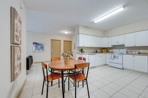 A kitchen with a table and chairs in the middle of the room.