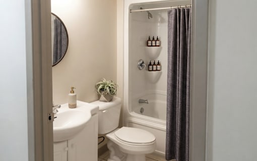 A white sink and toilet in a bathroom with a shower curtain.