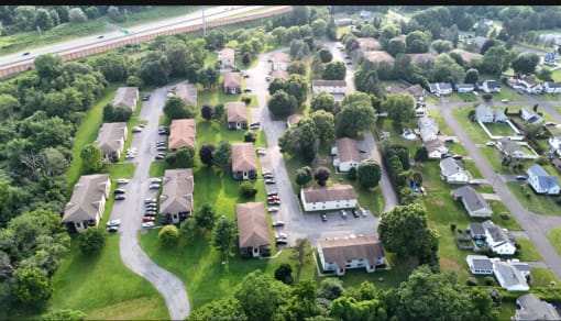 an aerial view of a neighborhood of houses with cars parked on the street
