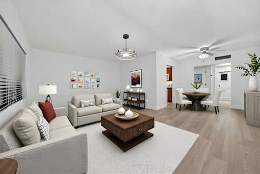 A living room with a grey couch, a coffee table, and a dining table with chairs.