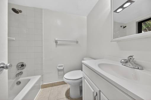 A white bathroom with a toilet, sink, and bathtub.