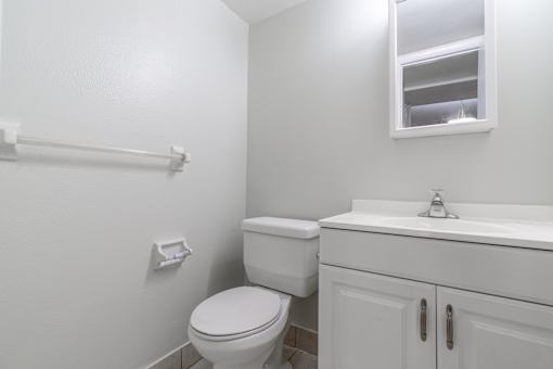 a white bathroom with a toilet and a sink