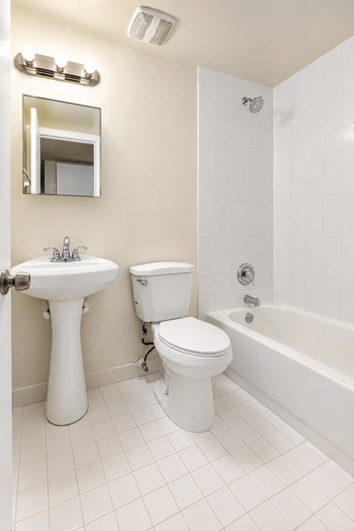 A white bathroom with a sink, toilet and bathtub.