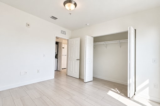 A room with a white door and a white closet.