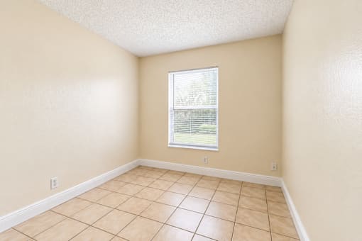 A room with a window and tiled floor.