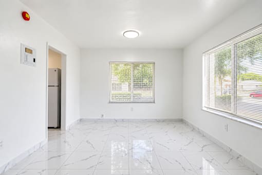 A white room with a marble floor and a window with blinds.