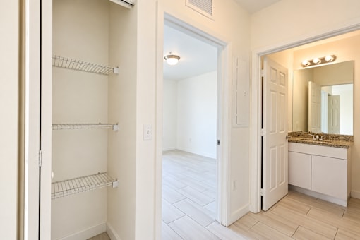 A white bathroom with a large mirror and a vanity.
