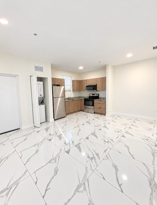 A kitchen with a marble floor and wooden cabinets.