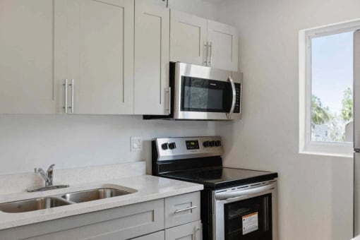 a kitchen with a sink and a stove and a microwave