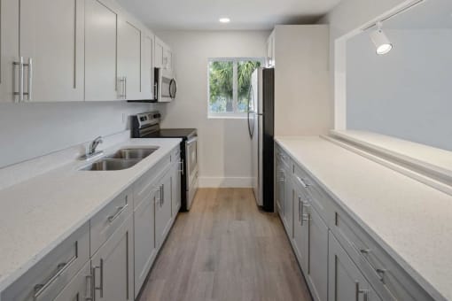 a kitchen with white cabinets and a black refrigerator