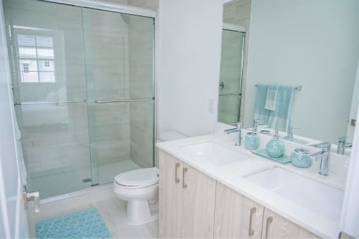 A bathroom with a shower and a sink and a toilet