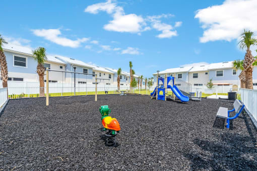 Aplayground with a childs toy in front of some apartments