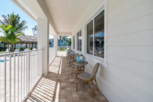 A patio with chairs and a table on a balcony
