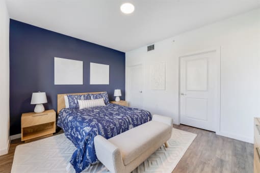 A bedroom with a bed and a blue wall and a white door