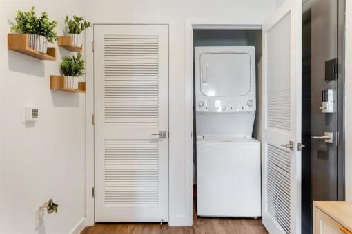 A small laundry room with a white refrigerator and a washer and dryer