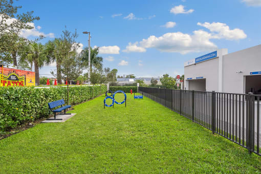 A grassy park with benches and a fence