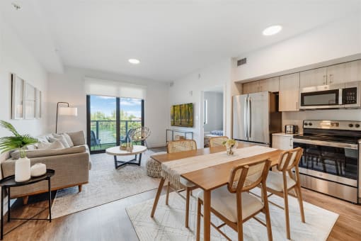 An open living room with a dining room table and a kitchen