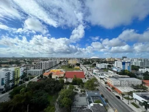 an aerial view of a city with a blue cloudy sky