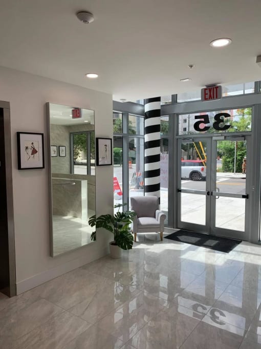 a lobby with a exit sign and glass doors