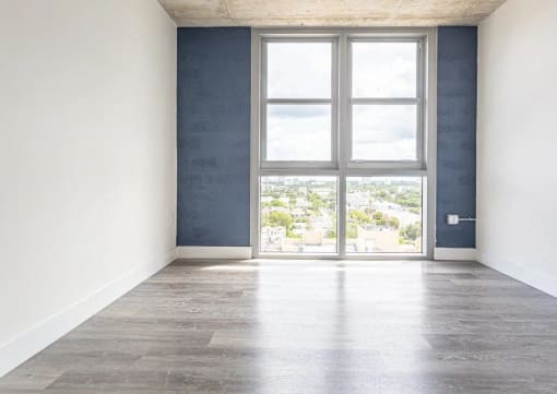 an empty room with a window and concrete floors