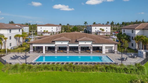 a house with a swimming pool in front of some buildings