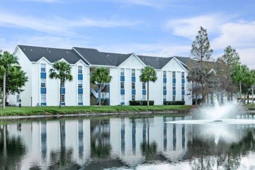 a building with a fountain in front of a lake
