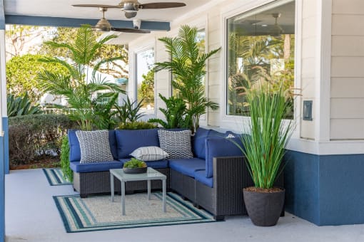 a porch with blue furniture and potted plants