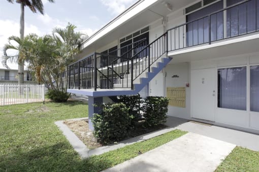 the outside of a house with a staircase and a yard