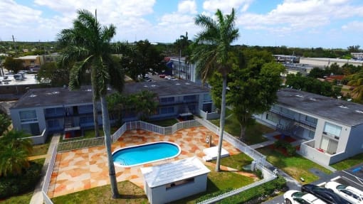 an aerial view of a swimming pool in front of some buildings